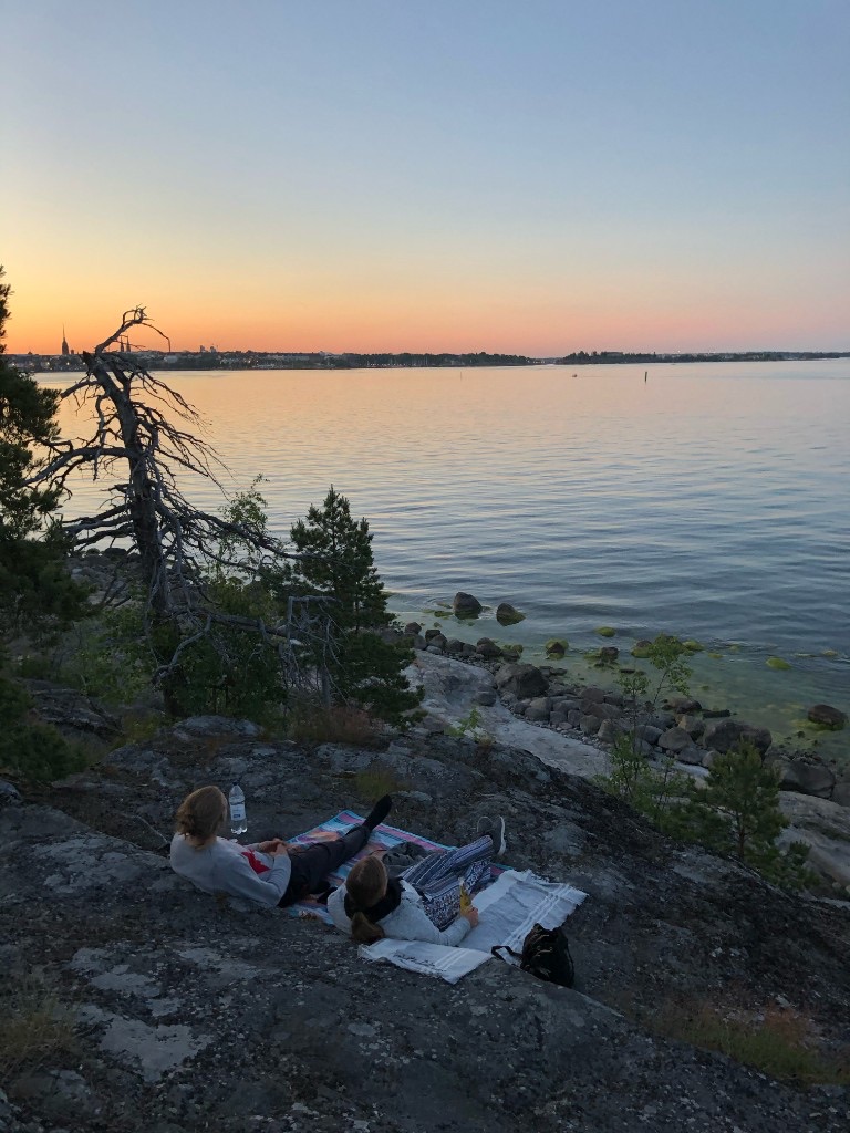 A midsummer evening picnic on the rocks by the sea in Helsinki